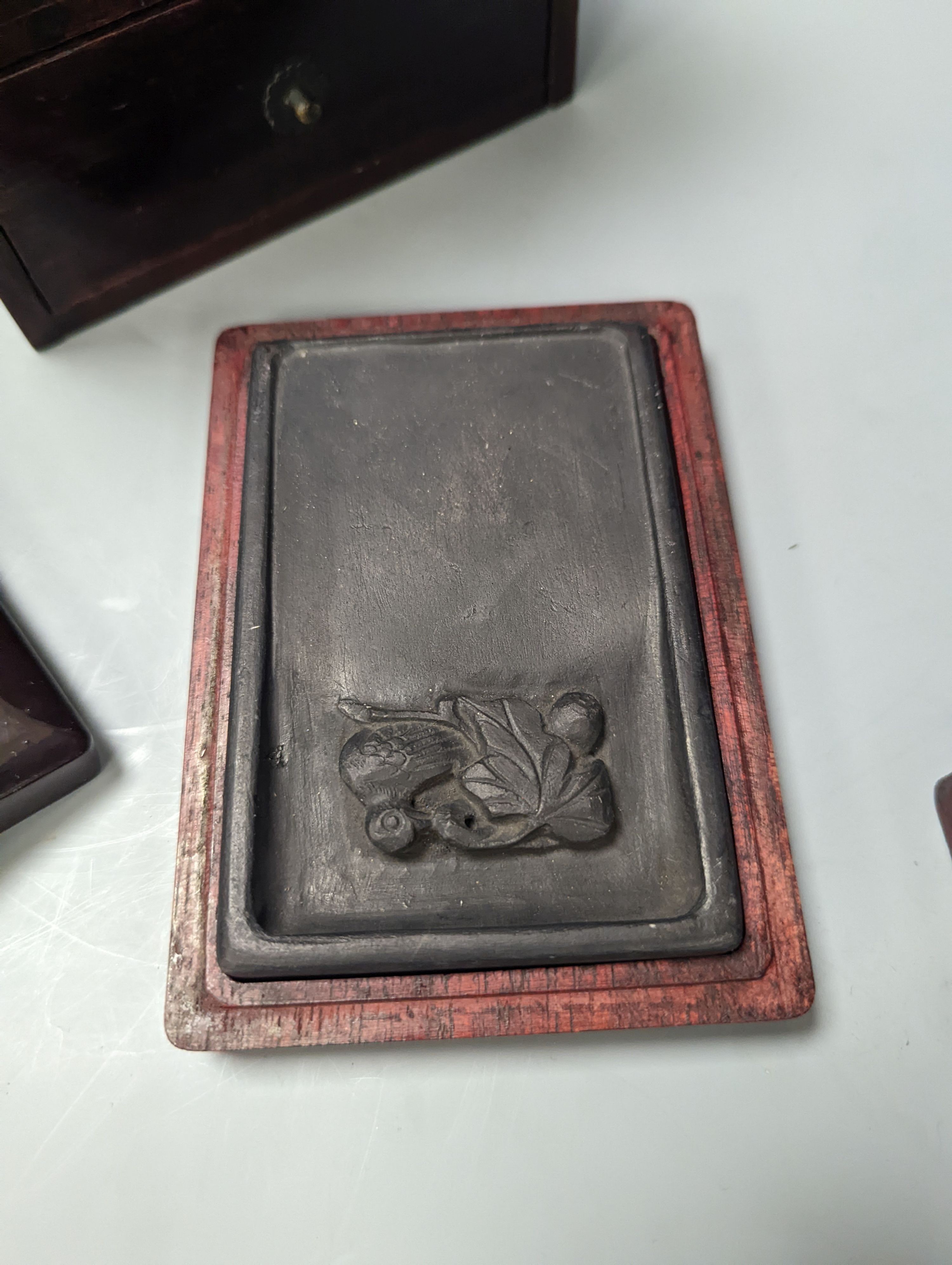 Three Chinese ink-stones, two in fitted boxes and a Japanese writing box, box 26 cms deep 14-5 wide.